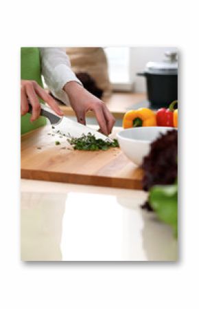 Close-up of human hands cooking vegetables salad in kitchen on the glass table with reflection. Healthy meal and vegetarian concept