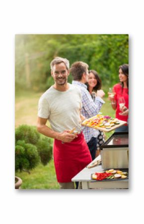 Looking at camera,  a nice man preparing a plancha for friends