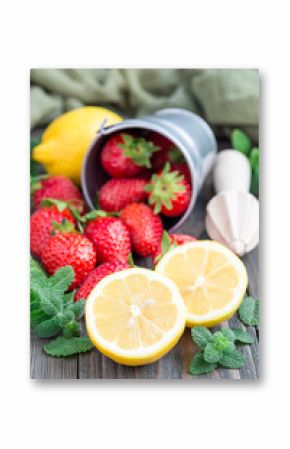 Ingredients for homemade strawberry lemonade on wooden table, vertical