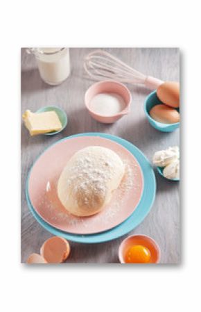 Baking ingredients and dough on wooden background