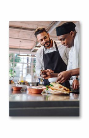 Chefs cooking new food dish in kitchen