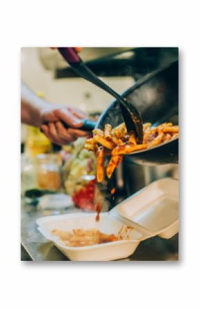 Chef cook pours spaghetti into fast food plastic delivery pack