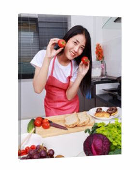 woman holding tomato in kitchen room