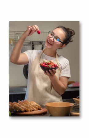 Woman holds fresh strawberries in the kitchen