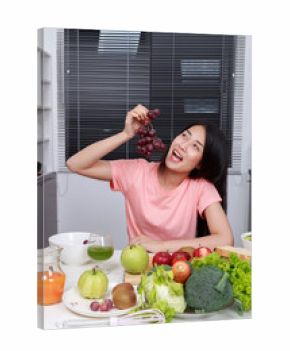woman eating grape in kitchen room