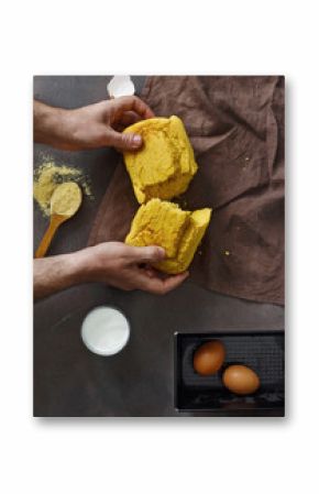 Mens hands break freshly baked cornbread top view