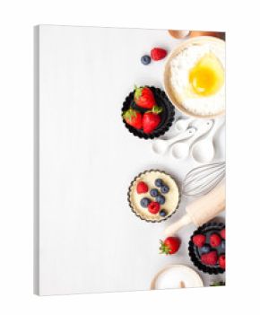 Baking utensils and cooking ingredients for tarts, cookies, dough and pastry. Flat lay with eggs, flour, sugar, berries.Top view, mockup for recipe, culinary classes, cooking blog.