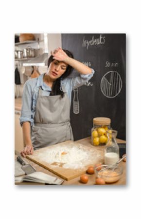 Tired woman in kitchen preparing dough