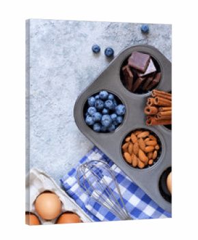 Food background. Ingredients for baking: flour, eggs, berries, chocolate on a concrete background.