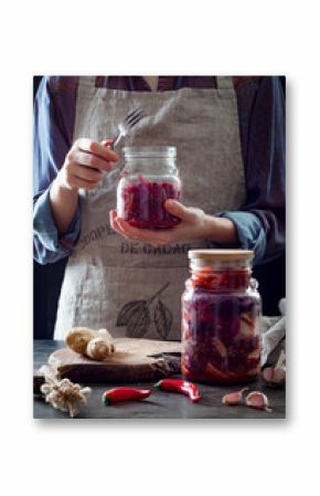 Cabbage kimchi in glass jar. Woman preparing purple cabbage and watermelon radish kimchi. Fermented and vegetarian probiotic food for gut health