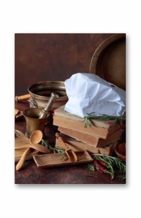 White chef's hat and old cookbooks.