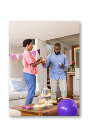 Celebrating at home, couple preparing snacks for festive family gathering