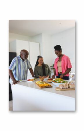 Family preparing delicious meal together in modern kitchen, sharing joyful moments