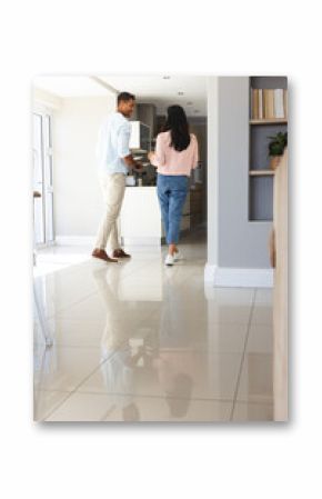 Diverse couple preparing breakfast in modern kitchen, using kitchen counter, copy space