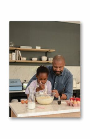 African American father and daughter preparing batter at marble island using whisk and mixing bowl
