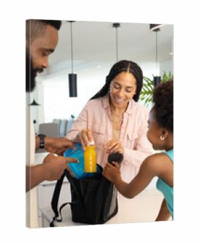 Family packing lunchbox together in kitchen, preparing for school day