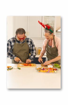 Christmas time, mature couple preparing vegetables in kitchen, at home