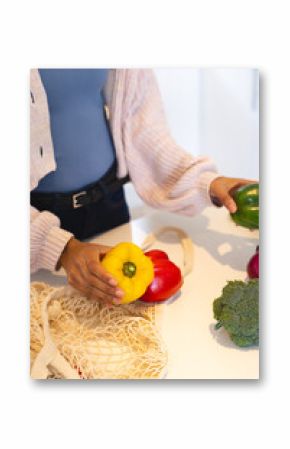 Preparing healthy meal, sorting colorful bell peppers and broccoli at kitchen counter, at home