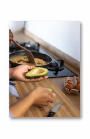 Young diverse couple preparing breakfast with avocados together in their kitchen