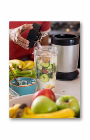 Young Asian woman preparing healthy smoothie with fresh fruits and vegetables