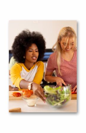 Preparing meal, young diverse friends chopping vegetables and enjoying cooking together