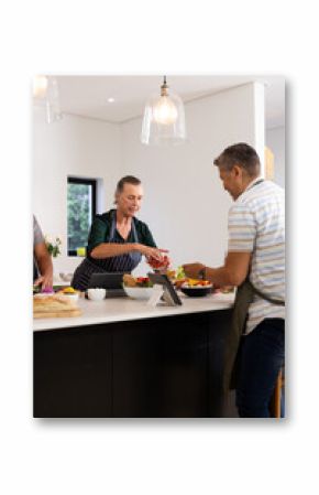 Cooking together, senior diverse friends preparing meal in modern kitchen, at home