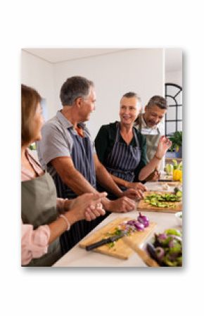 Preparing vegetables, senior diverse friends cooking together and enjoying conversation in kitchen,