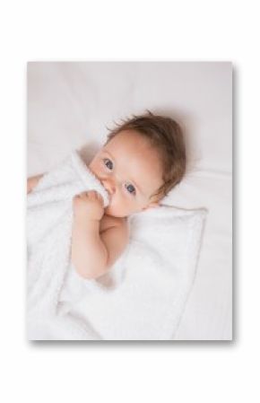 Cute baby holding blanket in crib