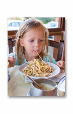 Adorable little girl eating spaghetti in outdoors restaraunt