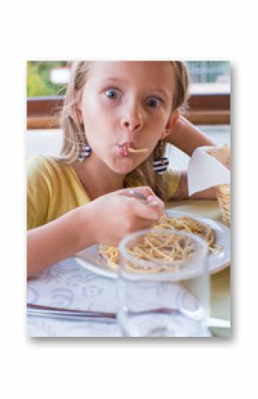 Adorable little girl eating spaghetti in outdoors restaraunt
