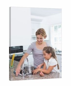 Mother and daughter filling pot with water