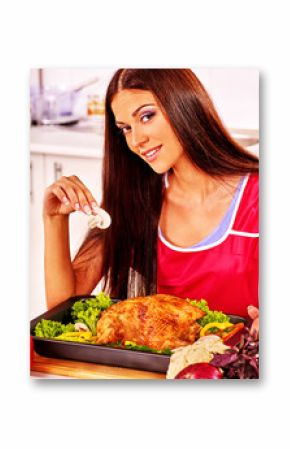 Woman cooking chicken at kitchen.