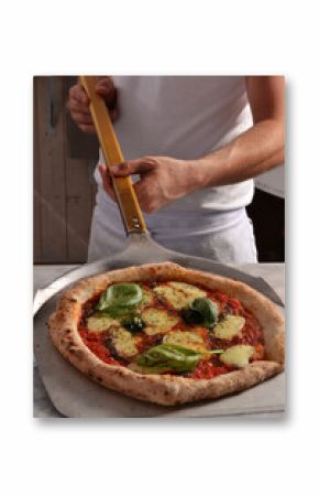 Cocinero sacando la pizza del horno.