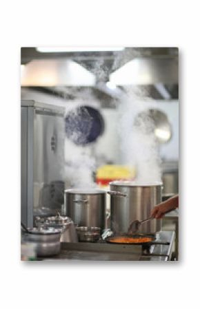 Cooking in a restaurant kitchen, steam over cooking pots