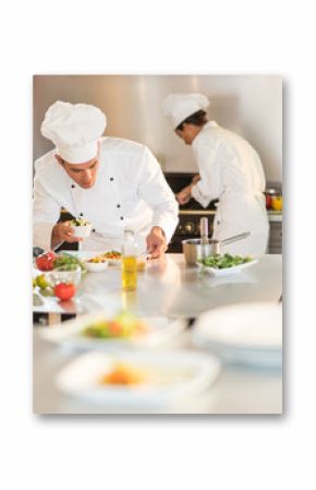 Two chefs are working in a starred restaurant kitchen.