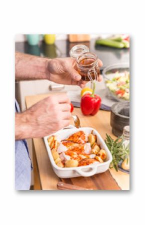 Man's or chef's hands preparing dinner in a roasting dish