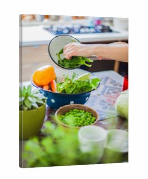 Woman cooking in kitchen with ingredients around her