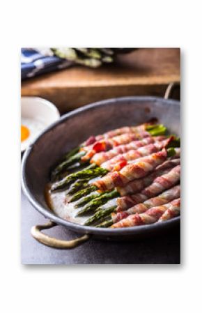 Asparagus. Asparagus and roll bacon. Grilled asparagus with rolled bacon and fried egg. Fried old pan full of rolled bacon with green asparagus and fried egg.