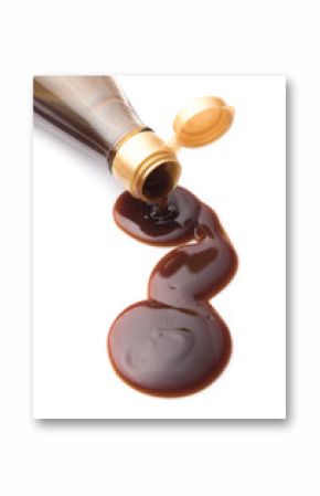 Oyster sauce poured from a bottle on a white background