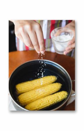 golden corn in black bowl on brown table