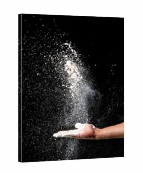 Hand and flour on black background