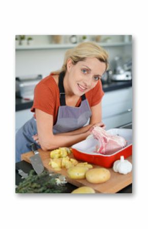 Portrait of smiling blond woman in kitchen cooking for dinner