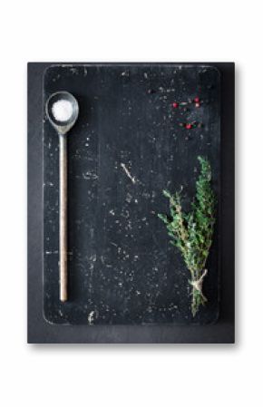 Thyme, salt and pepper on wooden cutting board, top view. Cooking food background. Old textured cutting board background