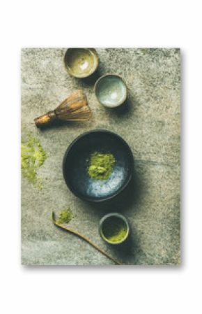 Flat-lay of Japanese tools for brewing matcha tea. Matcha powder in tin can, Chashaku spoon, Chasen bamboo whisk, Chawan bowl and ceremony cups over concrete background, top view, vertical composition