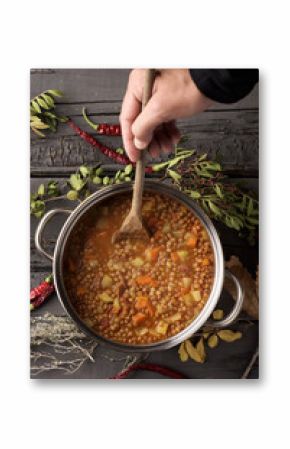 man stirring a lentil stew