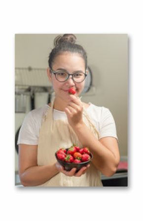 Woman holds fresh strawberries in the kitchen