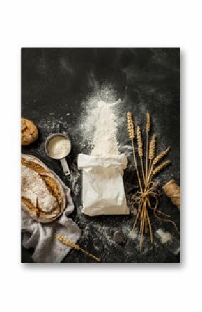 Bread, flour bag, wheat and measuring cup on black - kitchen