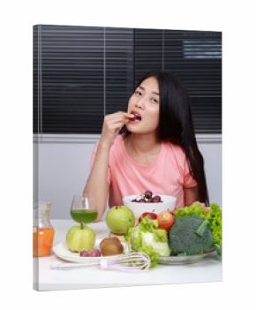 woman eating grape in kitchen room