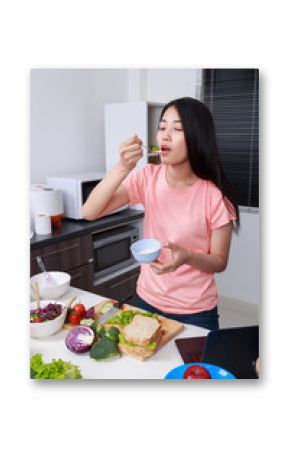 woman in kitchen preparing salad dressing in bowl