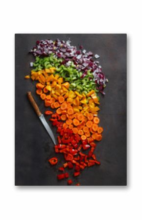 Chopped fresh vegetables with knife on dark background, top view